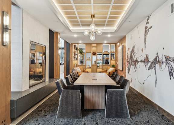A conference room with a long table surrounded by chairs.