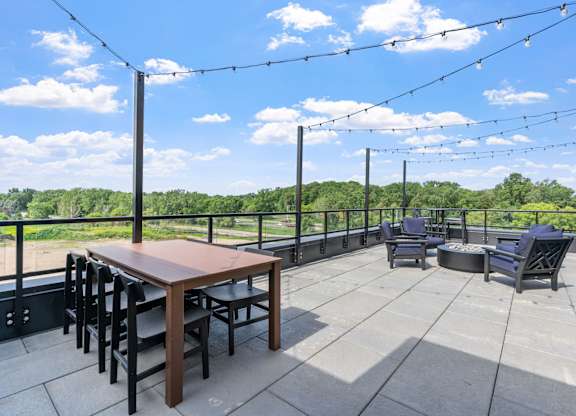 A patio with a table and chairs is set up on a balcony.