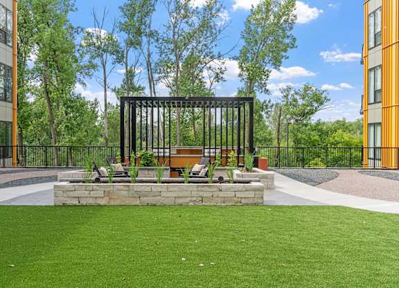 A black metal structure sits in the middle of a grassy area.