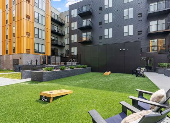 A modern outdoor seating area with a bench and chairs.