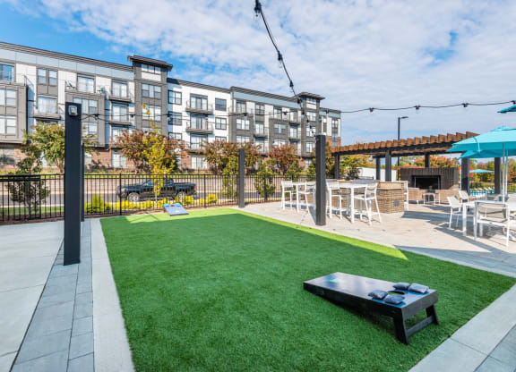 a yard with grass and tables and chairs and a fire pit