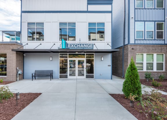 the entrance to a building with a bench in front of it