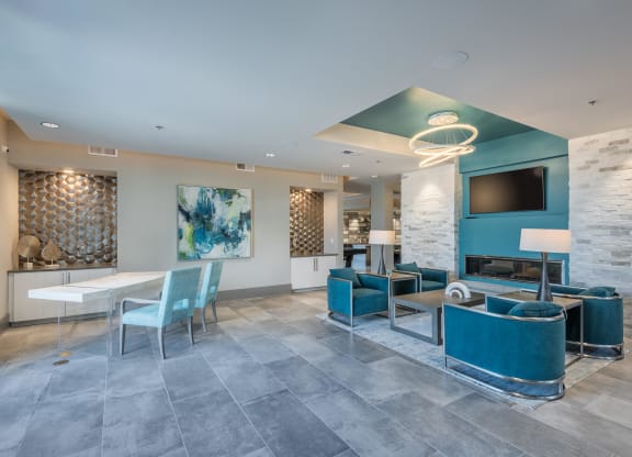 a lobby with blue chairs and tables and a tv