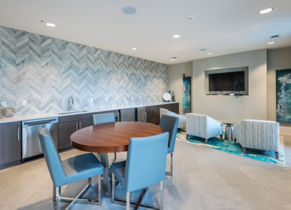 a dining room with a table and chairs and a kitchen with a tv