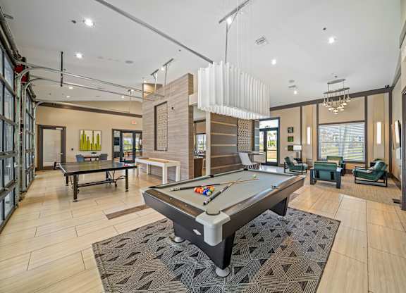 A room with a pool table in the middle.