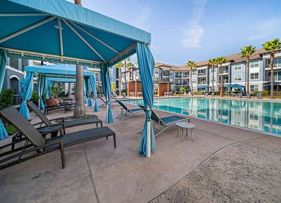 A poolside area with lounge chairs and a canopy.