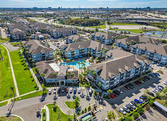 A large apartment complex with a swimming pool in the middle.