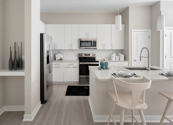 A modern kitchen with white cabinets and a black refrigerator.