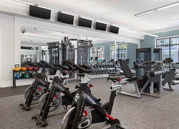 A gym with a row of stationary bikes.