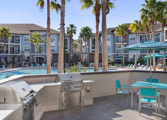 A poolside area with a grill and chairs.
