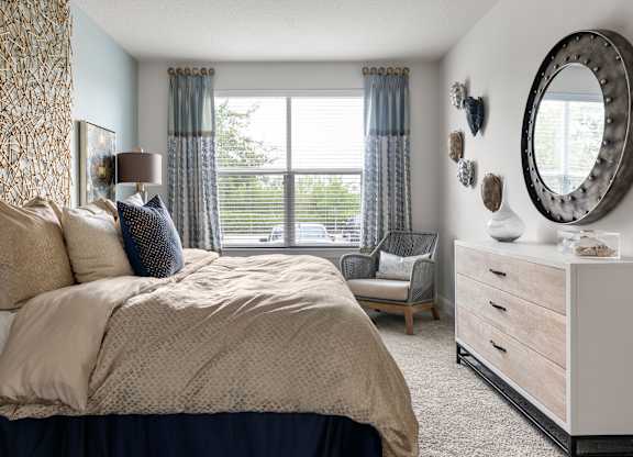 A bedroom with a large bed and a mirror on the wall.
