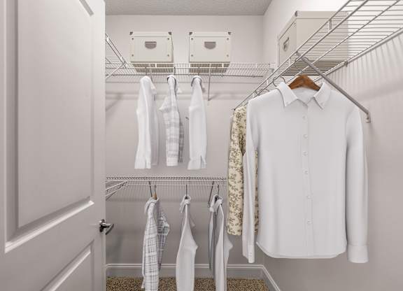 A white shirt hanging on a hanger in a closet.