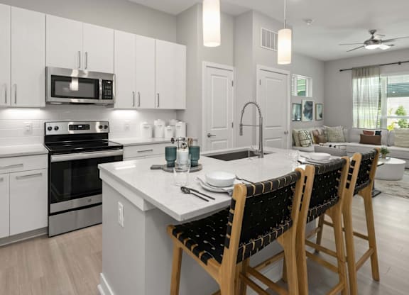 A modern kitchen with white cabinets and a central island.