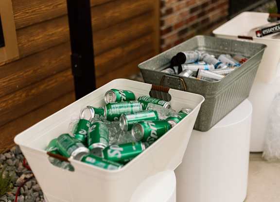 A white container is filled with green cans.