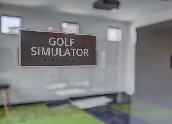 A sign that says Golf Simulator is hanging in a room.