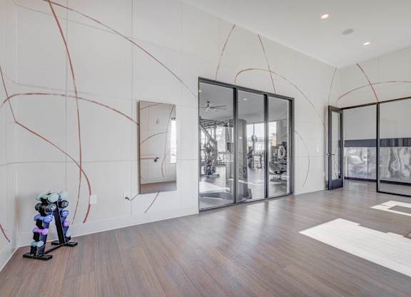 A modern room with a treadmill and a mirror on the wall.