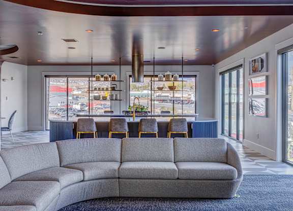 A grey couch in a room with a large window.