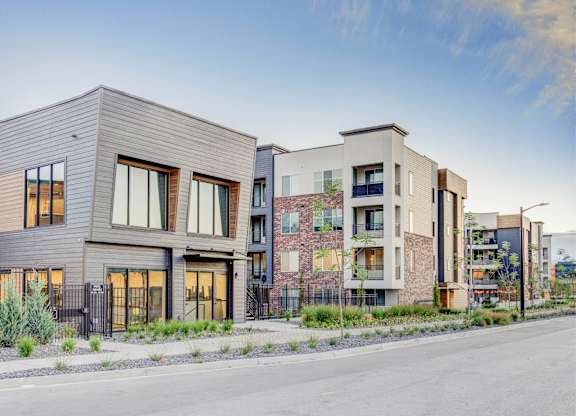 A modern residential area with two-story buildings and a street in front.