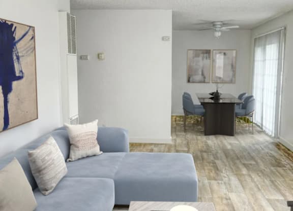 A living room with a grey couch and a painting on the wall.