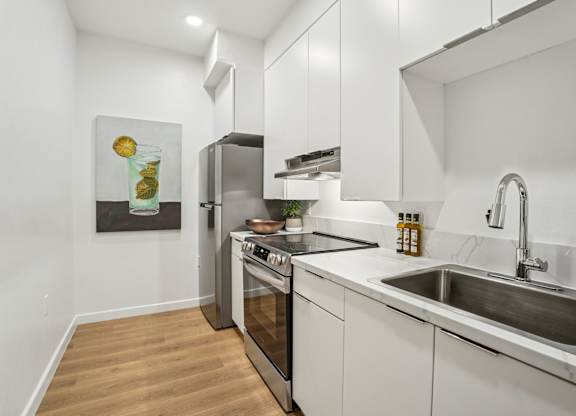 A modern kitchen with a stainless steel oven and white cabinets.