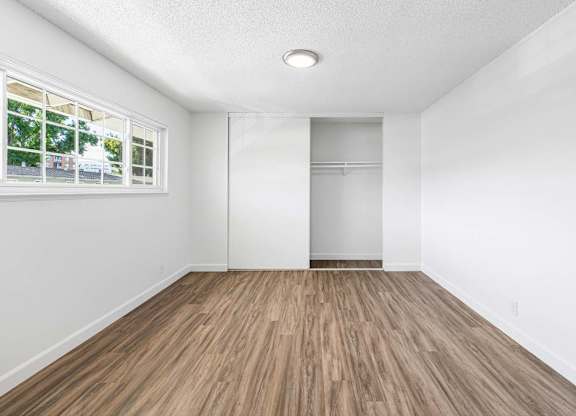 A room with wooden flooring and a window.
