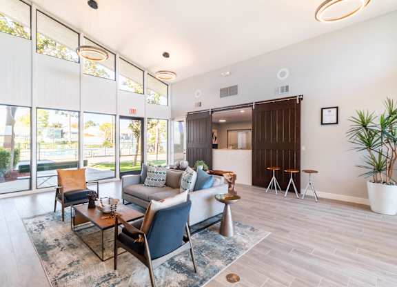 A living room with a couch, chairs, and a rug at Chaparral Apartments, Palmdale, CA