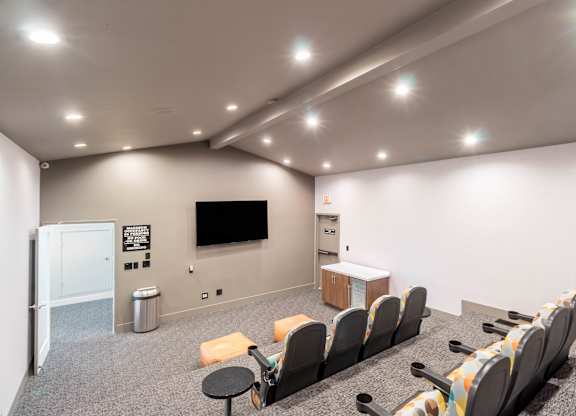 A room with a row of chairs facing a screen at Chaparral Apartments, Palmdale, California