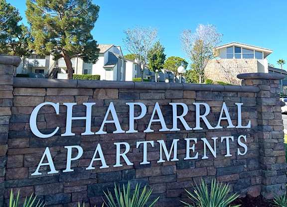 A sign that says Chaparral Apartments in front of some houses at Chaparral Apartments, California, 93551