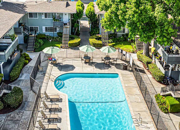 A swimming pool surrounded by a concrete patio and a grassy area.
