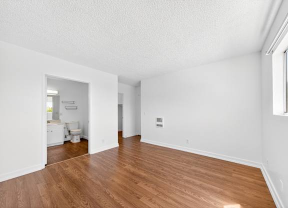 A large empty room with wooden floors and white walls.