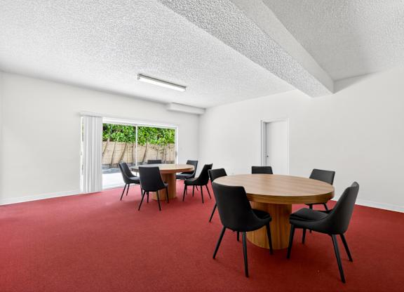 A conference room with a round table and chairs.