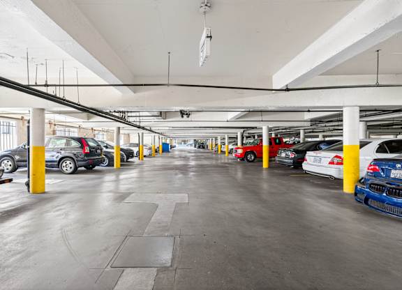 A parking garage with cars parked in yellow and blue columns.