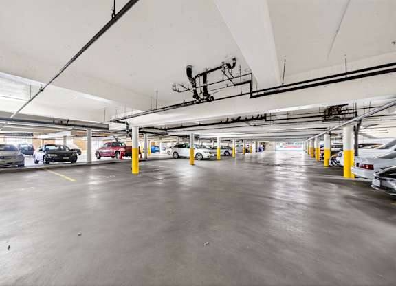 A parking garage with cars parked in yellow lines.