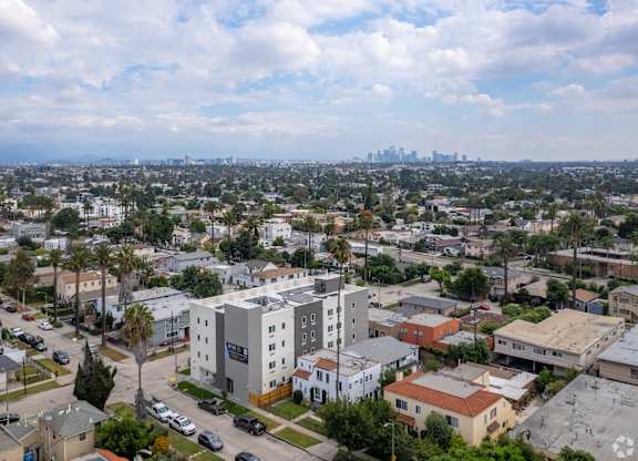 A cityscape with a mix of residential and commercial buildings under a partly cloudy sky.