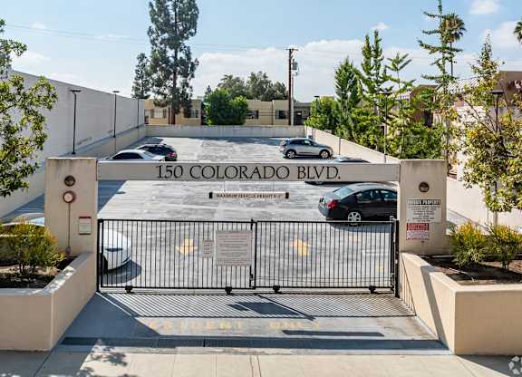 The entrance to a building with a sign that reads at Oak Park Apartments, Monrovia, 91016