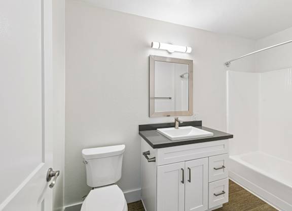 A white toilet sits next to a sink in a small bathroom.