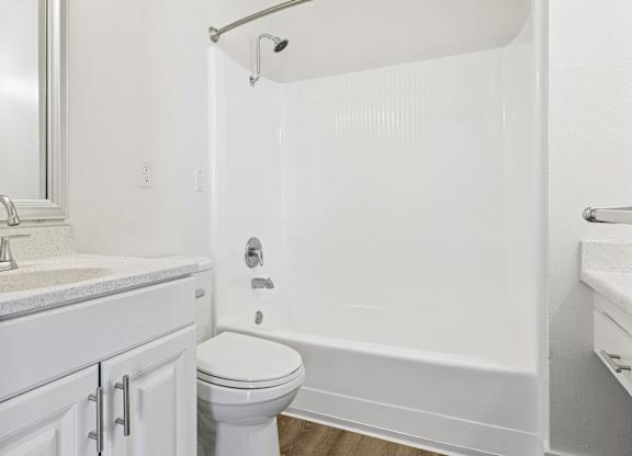 A white bathroom with a toilet, sink, and bathtub.