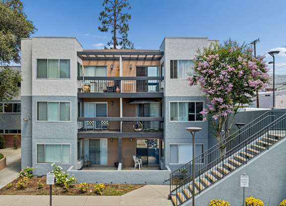 Apartment building with a tree in front of it.