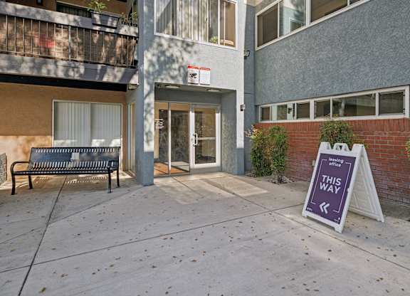 A sign in front of a building says "This Way".
