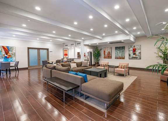 A living room with brown flooring and furniture at Oak Park Apartments, Monrovia, 91016
