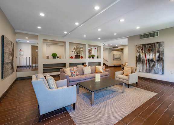 A spacious living room with a glass table and comfortable seating at Oak Park Apartments, Monrovia, 91016