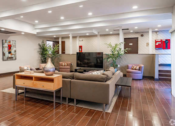 A living room with a brown sofa and a wooden coffee table at Oak Park Apartments, Monrovia, 91016