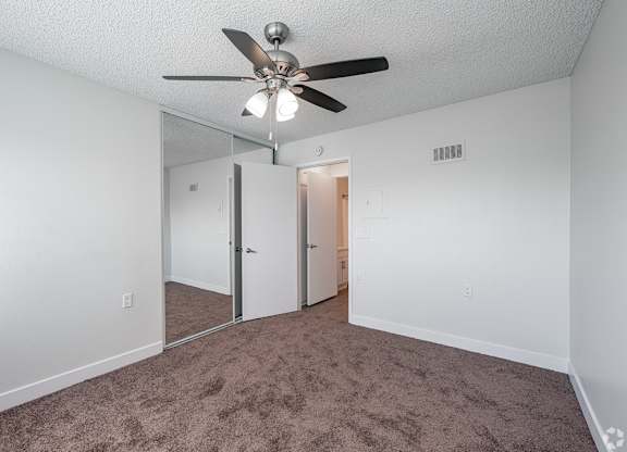 A room with a ceiling fan and carpeted floor at Oak Park Apartments, Monrovia, 91016