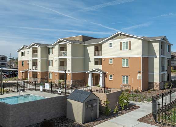 Apartment complex with a pool and a small storage shed.