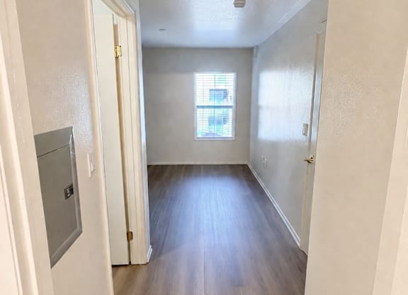 A long hallway with wood floors and white walls.