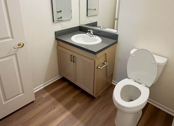 A white toilet sits next to a sink in a small bathroom.