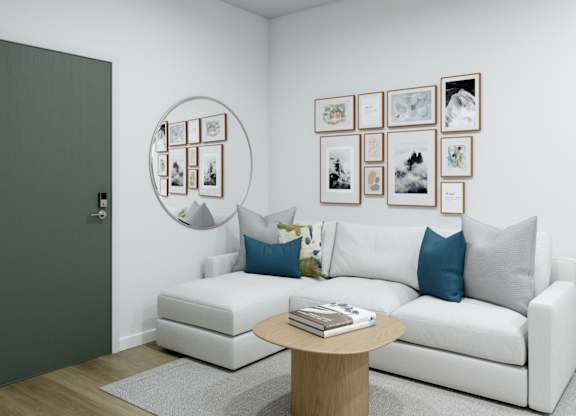 A white couch with blue pillows sits in a room with a coffee table in front of it.