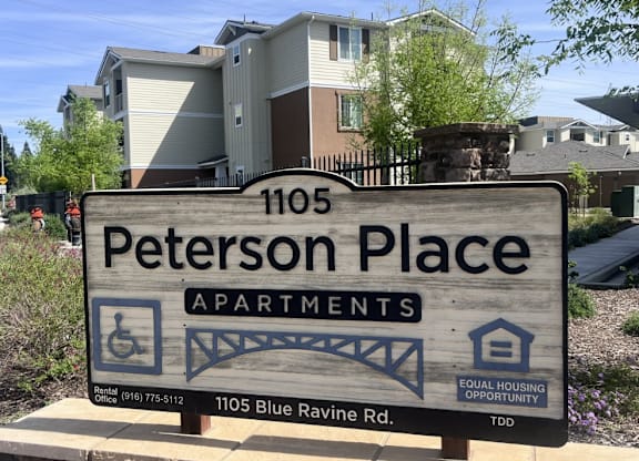 A sign for Peterson Place Apartments is in front of a building.