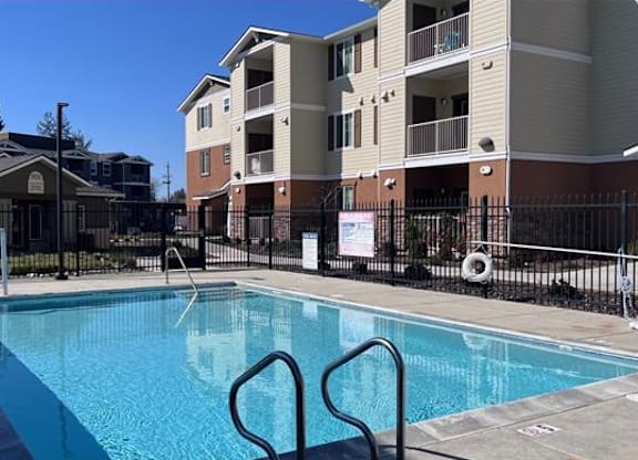 A swimming pool in front of apartment buildings.