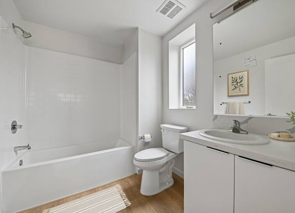 A white bathroom with a toilet, sink, and bathtub.